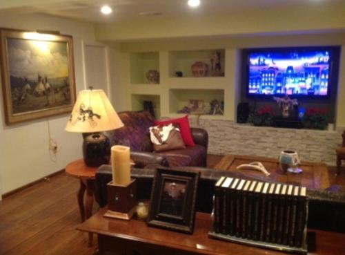 a living room with a couch and a tv at Trail Boss King EnSuite-Prairie Rose B&B - 1200 sq ft Suite in Cheyenne