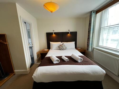 a bedroom with a large bed with two pillows on it at Castle Limes Hotel in Warwick