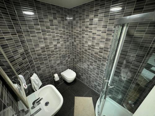 a bathroom with a toilet and a sink and a shower at Namaste Palace Hotel in Norwich