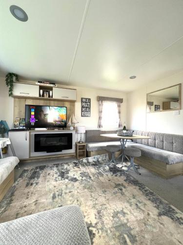a living room with a couch and a television at Berwick Holiday Park Haven in Berwick-Upon-Tweed