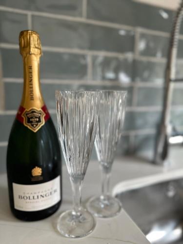 a bottle of champagne and two wine glasses on a counter at Apple-tree lodge in Taunton