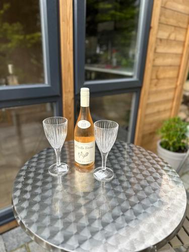 a bottle of wine and two wine glasses on a table at Apple-tree lodge in Taunton