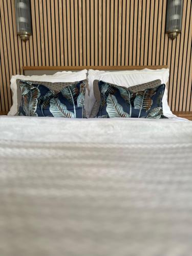 a bed with two pillows and a white bedsheet at Apple-tree lodge in Taunton