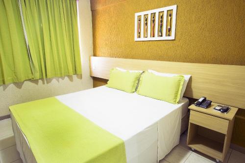
a bedroom with a bed and a desk at Rede Andrade Plaza Salvador in Salvador
