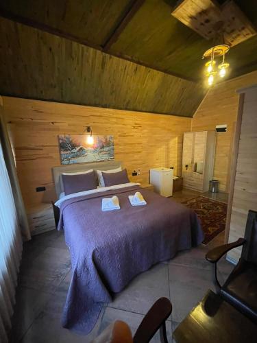 a bedroom with a large bed in a wooden room at pınar kır evi in Artvin