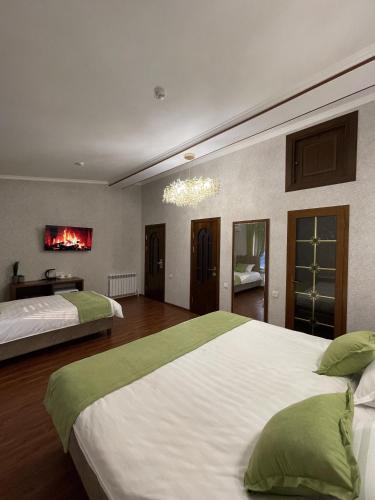 a large bedroom with two beds and a chandelier at Vasiev's Hotel in Samarkand