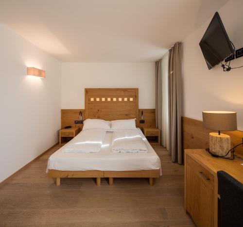 a bedroom with a bed and a flat screen tv at Albergo Caffe Centrale in Mezzocorona
