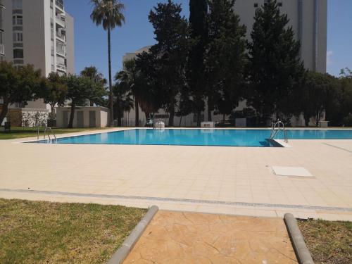 an empty swimming pool with trees and buildings at Blue Ocean Apartments in Benalmádena
