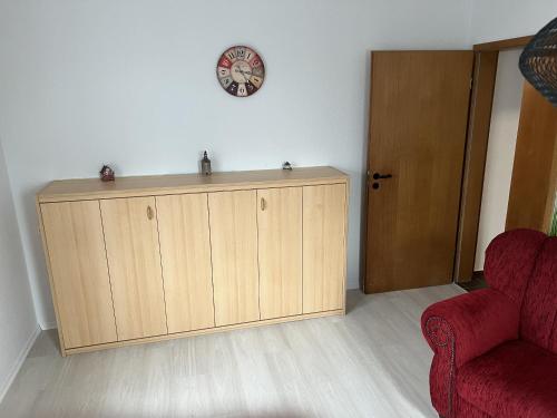 a room with a cabinet and a clock on a wall at Toms great house of hygge in Süderstapel