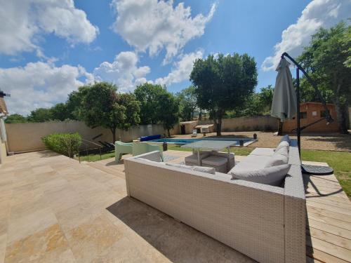 une terrasse avec une table, un parasol et une piscine dans l'établissement Maison 6 personnes, à Saint-Saturnin-lès-Apt