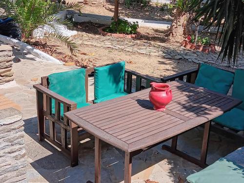 a wooden table and chairs with a vase on it at Villa Rena in Batsi