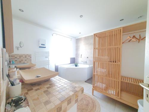 une grande salle de bain avec une baignoire et un lavabo dans l'établissement Maison 6 personnes, à Saint-Saturnin-lès-Apt
