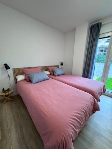 two beds sitting next to each other in a room at Apartamento con jardin Long Beach Loredo in Loredo