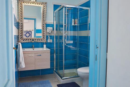 a blue bathroom with a shower and a toilet at B&B AcquaDolce in Cala Gonone