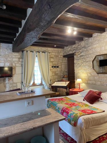 a bedroom with a bed and a stone wall at La Maison d'Alienor, Gite à Chablis in Chablis