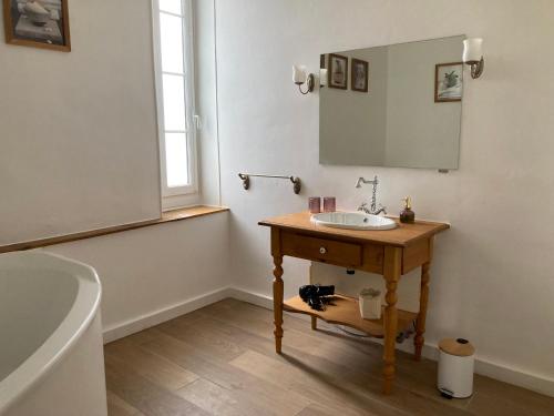 a bathroom with a sink and a mirror and a tub at Les Croque-Notes, chambres et table d'hôtes in Lorignac