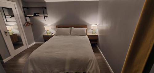 a bed in a room with two night stands and two lamps at Garden Lodge in Belfast