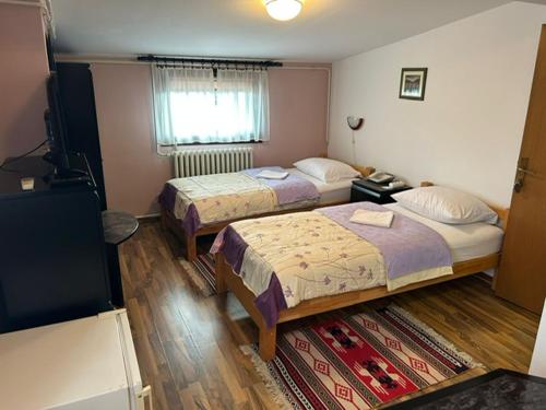 a hotel room with two beds and a television at Hondo Rooms & Apartments in Sarajevo