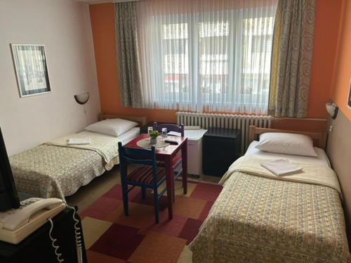 a room with three beds and a table and a window at Hondo Rooms & Apartments in Sarajevo