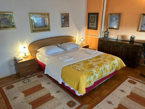 a bedroom with a large bed with two nightstands and two tables at Hondo Rooms & Apartments in Sarajevo