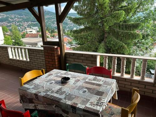 a table and chairs on a balcony with a view at Hondo Rooms & Apartments in Sarajevo