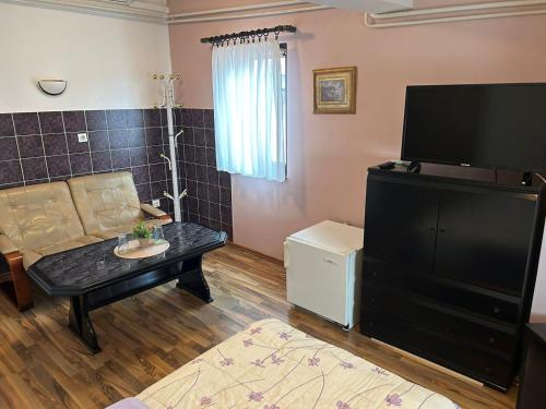 a living room with a couch a table and a tv at Hondo Rooms & Apartments in Sarajevo