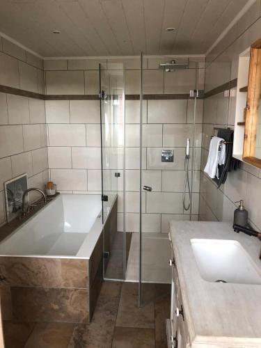 a bathroom with a tub and a sink and a shower at Ferienwohnung Enzo in Langenhorn