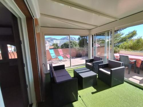 une chambre avec des chaises et une vue sur un patio dans l'établissement Duplex T4 toit terrasse plages parc Borély 13008 MARSEILLE, à Marseille