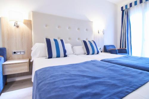 a bedroom with two beds with blue and white at Los Geranios in Port de Soller