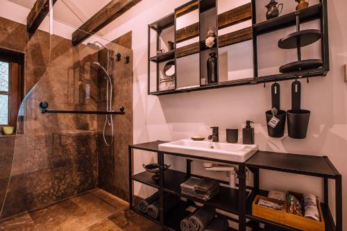 a bathroom with a sink and a shower at Bosrust Bungalow in Vught