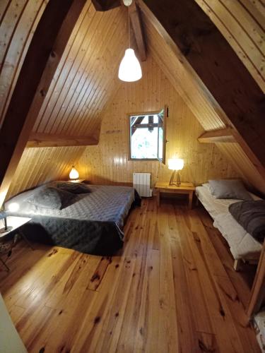 a attic bedroom with two beds and a window at CHALET 9 "Pensée" in Garin