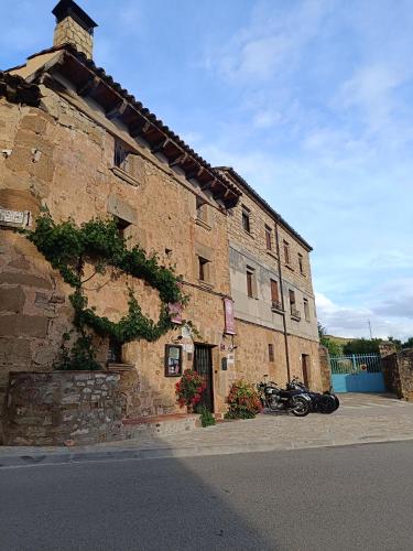 an old stone building with a motorcycle parked next to it at Hotel Rural el Arrabal Siguenza in Sigüenza