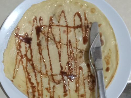 a white plate with a cake with chocolate sauce at T&T Homestay in Kuta Lombok