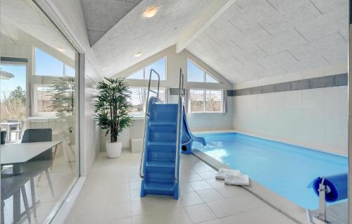 a swimming pool with a blue slide in a room at Lovely Home In Væggerløse With Sauna in Marielyst