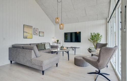 a living room with a couch and a table and chairs at Lovely Home In Væggerløse With Sauna in Marielyst