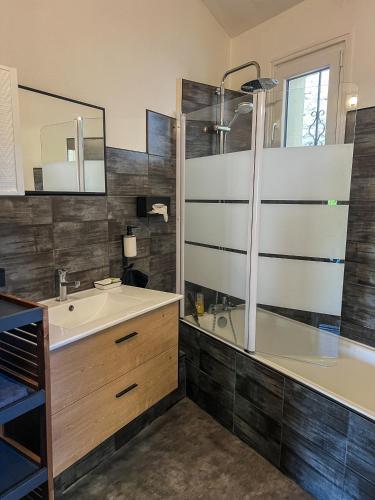 une salle de bain avec un lavabo, une douche et une baignoire dans l'établissement Maison proche de l'Estuaire, à Brie-sous-Mortagne