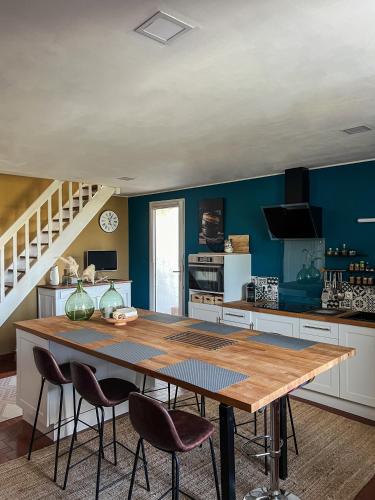 une cuisine avec une grande table et des chaises en bois dans l'établissement Maison proche de l'Estuaire, à Brie-sous-Mortagne