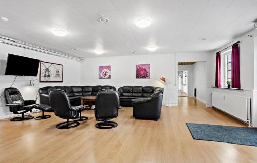 a living room with a leather couch and chairs at 11 Bedroom Gorgeous Home In Hurup Thy in Hurup