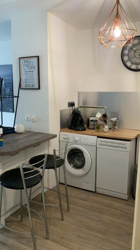 une cuisine avec une machine à laver et une table avec des chaises dans l'établissement Appart Entre Mer et Montagne, Linges Inclus, à Alénya