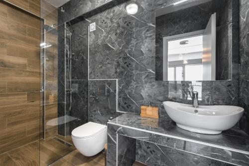a bathroom with a sink and a toilet and a mirror at Nikiti Summer Gem 1 by Luxlikehome in Nikiti