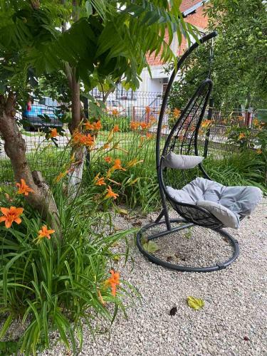 a black chair sitting in a garden with flowers at Una in Bihać