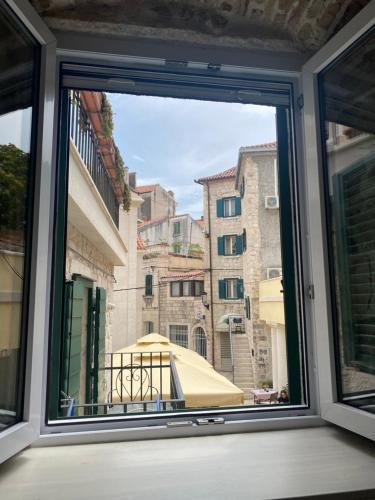 una ventana con vistas a una sombrilla en Room N&M - Diocletians palace en Split