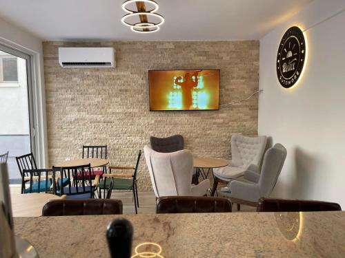 a room with chairs and tables and a clock on the wall at Relax Apartmani in Sutomore