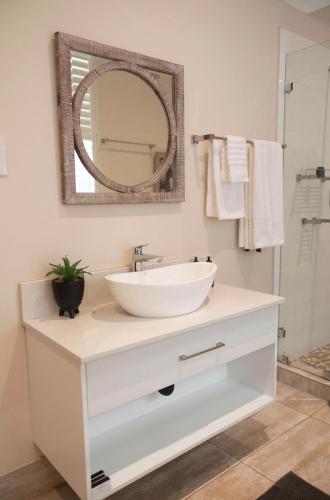 a bathroom with a white sink and a mirror at Ridgeway Place in Harare