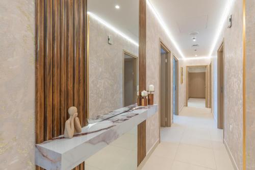 a bathroom with a sink and a long hallway at Globalstay Creek Horizon Modern Apartments in Dubai