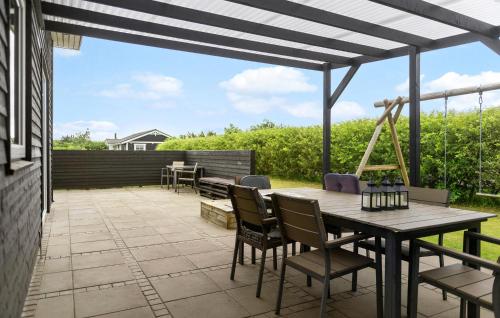 a patio with a wooden table and chairs at Pet Friendly Home In Hemmet With Wifi in Hemmet