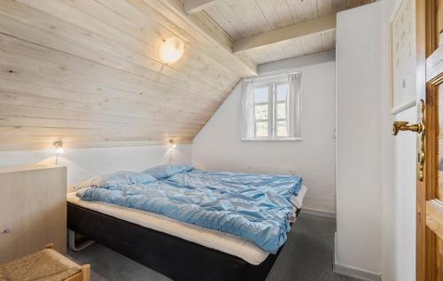 a bed in a room with a wooden ceiling at 4 Bedroom Stunning Home In Fanø in Fanø