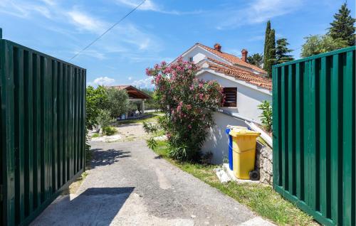 a gate in front of a house with a fence at Stunning Apartment In Omisalj With Wifi in Omišalj