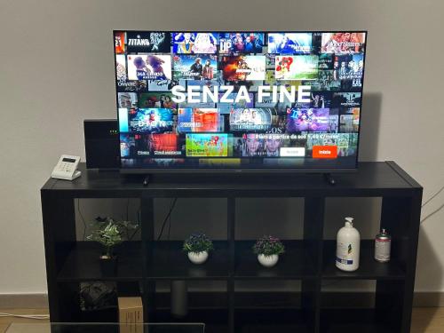 TV de pantalla plana en la parte superior de un centro de entretenimiento negro en Dalla Laretta di fronte all Acquario di Genova, en Génova