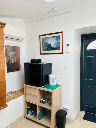 - un salon avec une télévision et une porte dans l'établissement Chambre de Cottage, à Moulézan